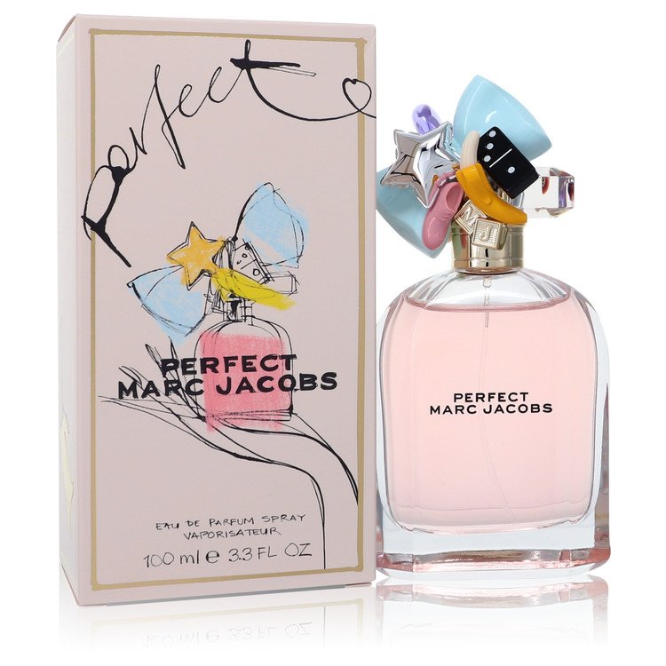 A clear glass perfume bottle with gold accents and a white label featuring the brand name, displayed on a wooden surface.