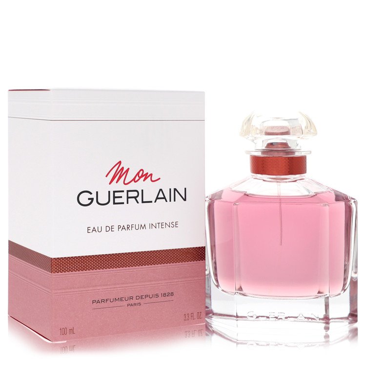 A clear glass bottle with gold accents and a black cap, labeled Mon Guerlain Intense Eau De Parfum 3.3 oz by The Fragrance Av