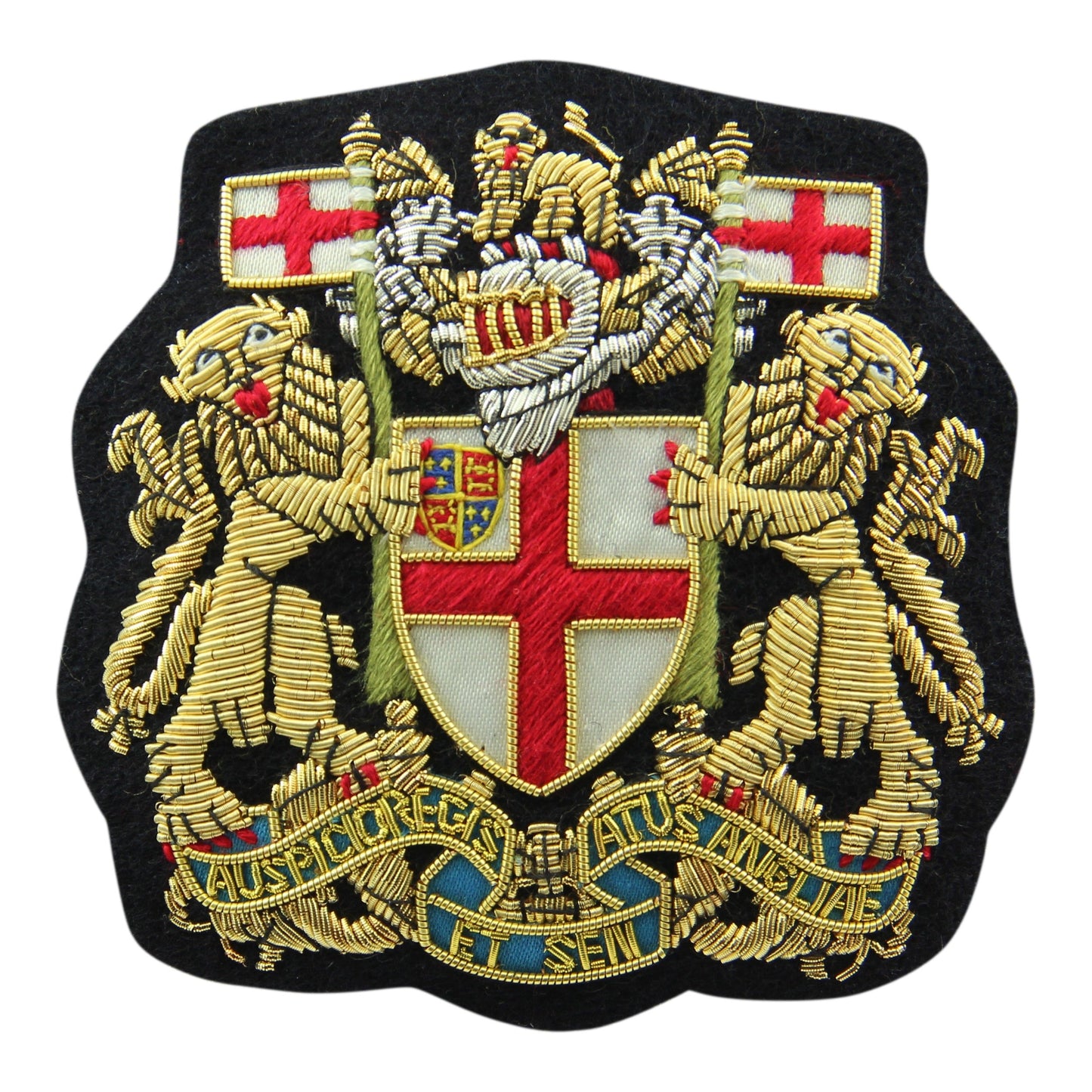 A brass blazer badge with intricate design, featuring the East India Company emblem, mounted on a dark blue cloth background