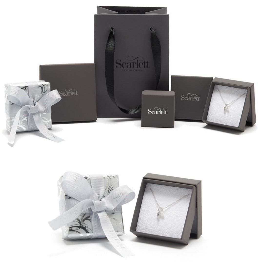 Silver paw print charm with personalized engraving on a jewelry display by Scarlett Jewellery.