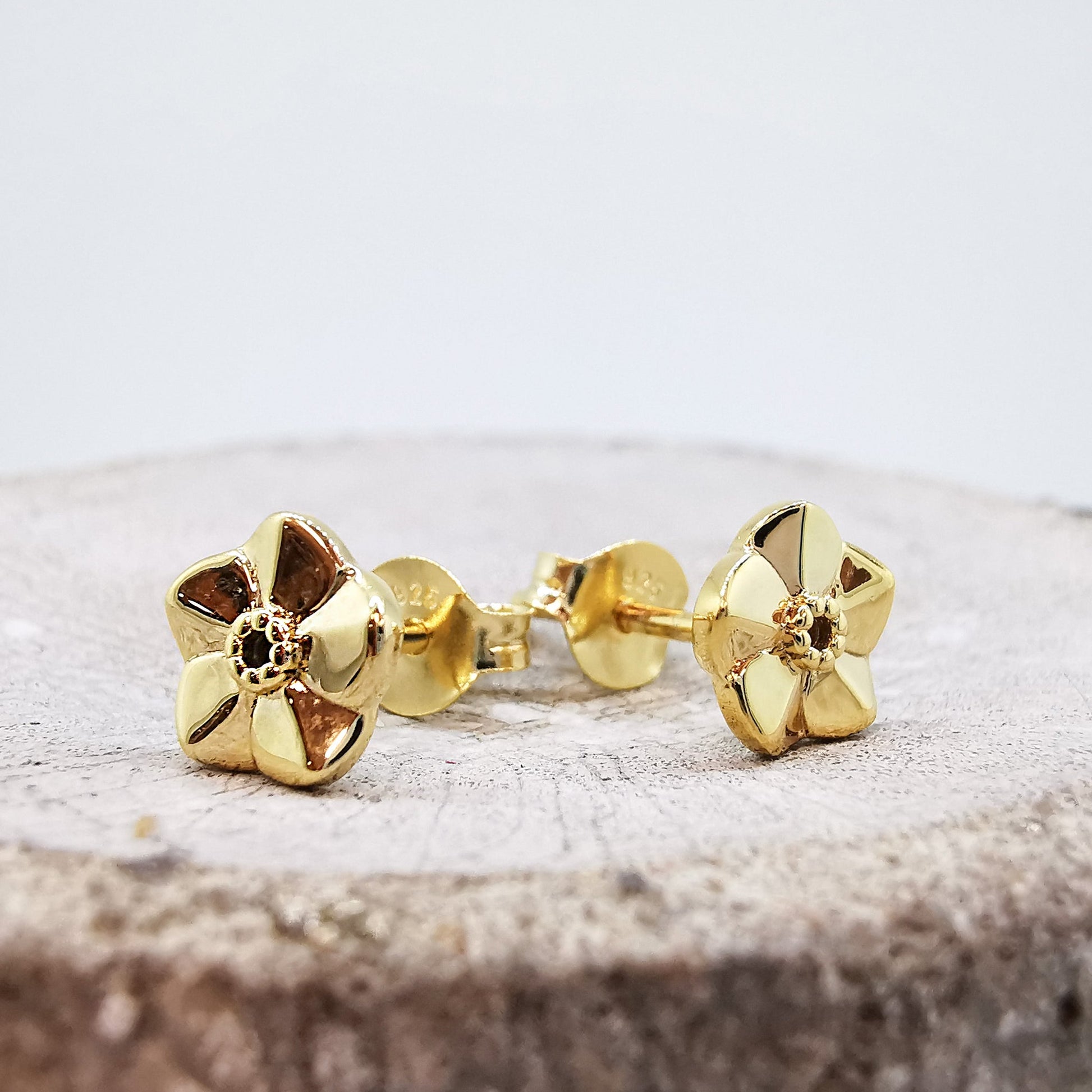 Tiny gold vermeil stud earrings with a delicate forget-me-not design by Scarlett Jewellery.