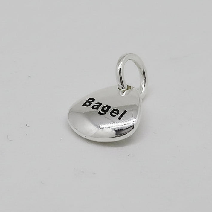 Silver pet paw print charm with personalized engraving by Scarlett Jewellery.