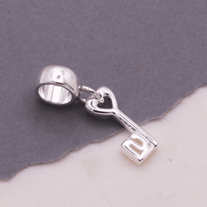 A silver 21st birthday charm with intricate detailing, displayed on a white background by Scarlett Jewellery.