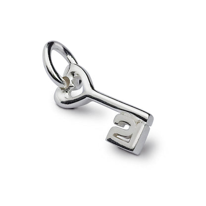 A silver 21st birthday charm displayed on a velvet background by Scarlett Jewellery.