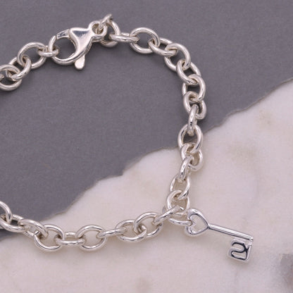 A silver 21st birthday charm displayed on a velvet background by Scarlett Jewellery.
