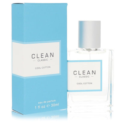 A clear glass bottle with a white label and silver cap, filled with light blue liquid, standing on a wooden surface by The Fr