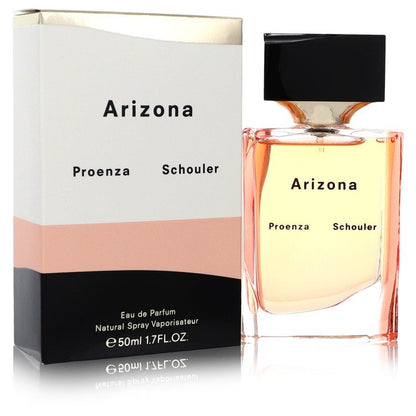 Blue glass bottle with gold accents resting on a white surface, labeled Proenza Schouler Arizona Eau de Parfum Spray for Wome