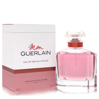 A clear glass bottle with gold accents and a black cap, labeled Mon Guerlain Intense Eau De Parfum 3.3 oz by The Fragrance Av