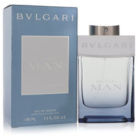 Blue glass bottle with silver cap resting on a wooden surface, featuring the Bvlgari logo, 3.4 oz eau de parfum spray for men