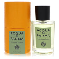 A clear glass bottle with a gold cap and blue label, standing on a white surface, labeled "Colonia Futura" by The Fragrance A
