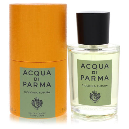 A clear glass bottle with a gold cap and blue label, standing on a white surface, labeled "Colonia Futura" by The Fragrance A