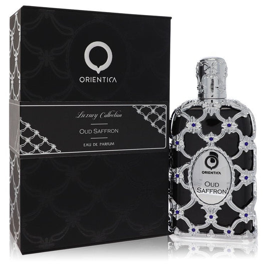 A dark glass bottle of Al Haramain Orientica Oud Saffron Eau De Parfum Spray 5 oz with gold accents on a wooden table by The 