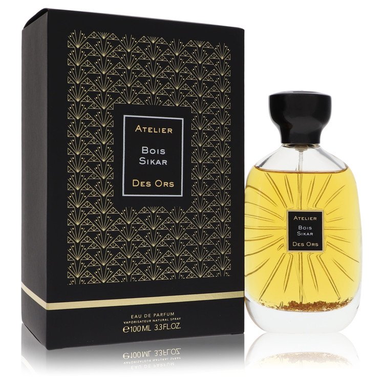 A golden perfume bottle with a wooden cap resting on a white surface by The Fragrance Avenue.