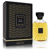A golden perfume bottle with a wooden cap resting on a white surface by The Fragrance Avenue.