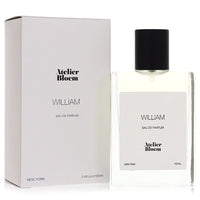 A clear glass bottle of Atelier Bloem William Eau De Parfum Spray with a minimalist white label and gold accents, standing on