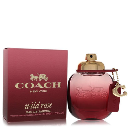 A clear glass perfume bottle with a pink rose design and gold accents, labeled "Coach Wild Rose Eau de Parfum" by The Fragran