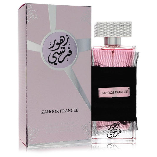 A clear glass bottle with gold accents and a black cap, labeled Al Zaafaran Zahoor Francee, standing on a white surface by Th