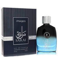 A clear glass bottle with a gold cap and black label, labeled "Dumont Murjan Sarai" by Dumont Paris, standing on a wooden sur