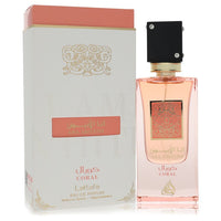 Coral-colored perfume bottle with gold label, standing on a wooden surface, Lattafa Ana Abiyed Eau de Parfum Spray 2 oz by Th