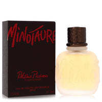 A blue glass bottle with a minimalist design and gold accents, labeled Minotaure by Paloma Picasso, standing on a white surfa
