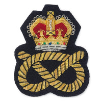 Black blazer badge with gold crown and knot emblem on a white background by Benson & Clegg.