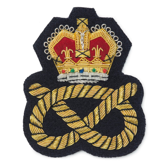 Black blazer badge with gold crown and knot emblem on a white background by Benson & Clegg.