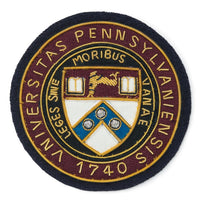 Blue university of pennsylvania blazer badge on a white background by Benson & Clegg.