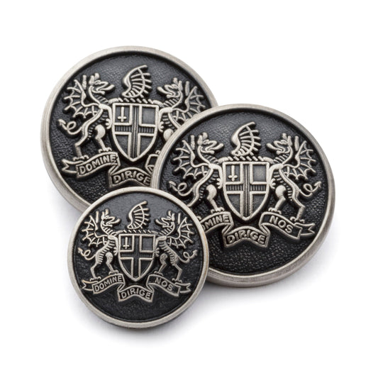Antique silver blazer button set with detailed engraving, displayed on a dark background by Benson & Clegg.