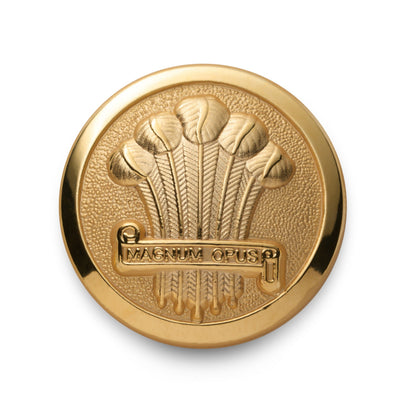 A brass heraldic plume blazer button with detailed engraving, mounted on a black fabric background, by Benson & Clegg.
