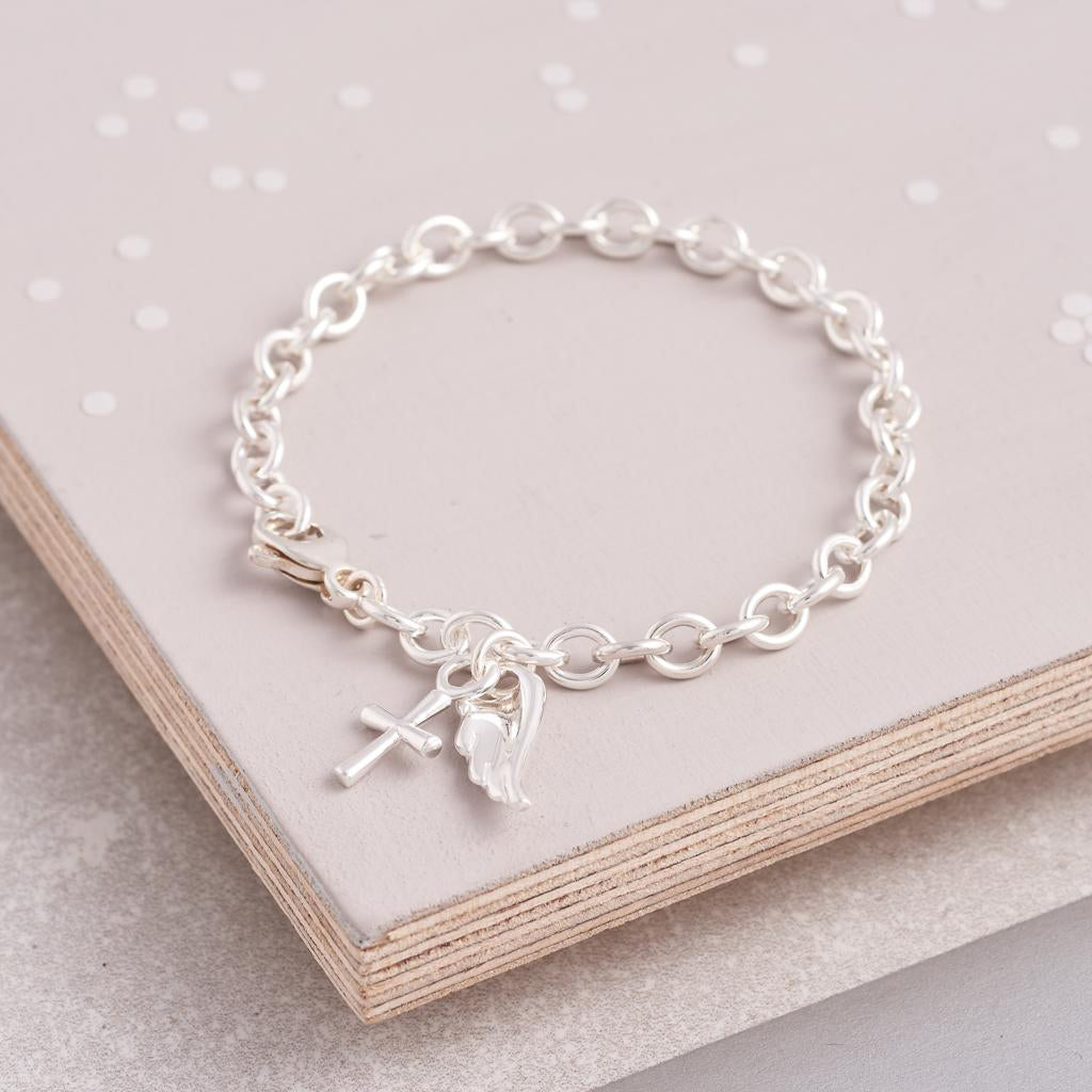 Silver charm bracelet featuring a delicate christening charm, styled on a white background by Scarlett Jewellery.