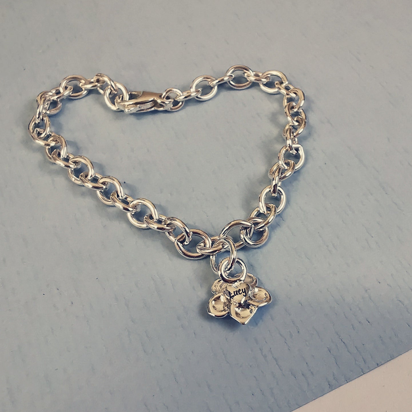 A silver personalised charm bracelet with a forget-me-not design by Scarlett Jewellery