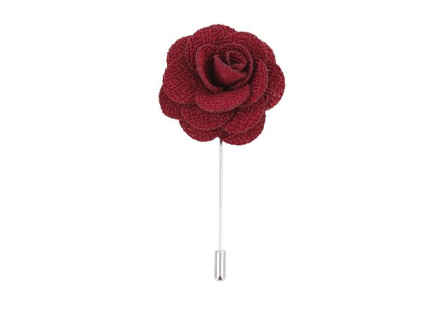 A burgundy silk boutonniere with delicate detailing, displayed on a white background by Benson & Clegg.