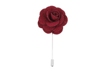 A burgundy silk boutonniere with delicate detailing, displayed on a white background by Benson & Clegg.
