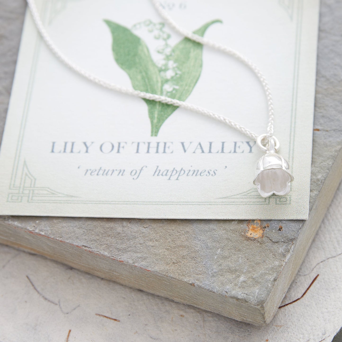 Silver lily of the valley flower charm with delicate details, styled on a necklace chain by Scarlett Jewellery.