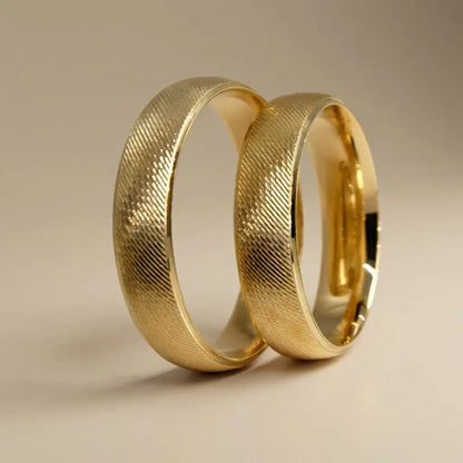 A brushed 5mm gold wedding band in 9ct gold worn on a finger by Majestic Jewellery