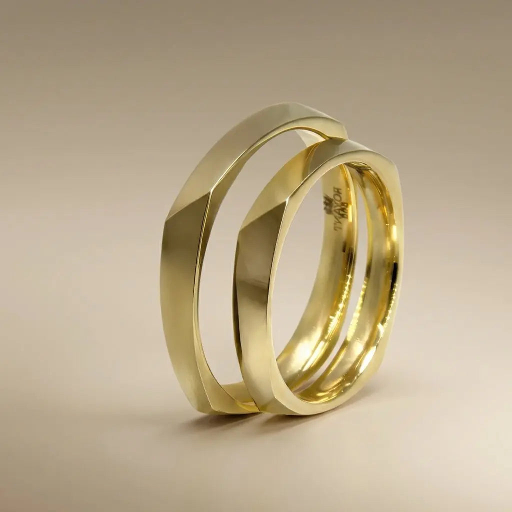 A 3mm gold wedding band with a faceted design, shown in 18ct gold, featuring a sleek and modern finish by Majestic Jewellery.