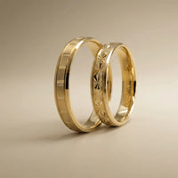 A 4mm gold wedding band with a starburst faceted design in 14ct gold, shown against a black background by Majestic Jewellery.