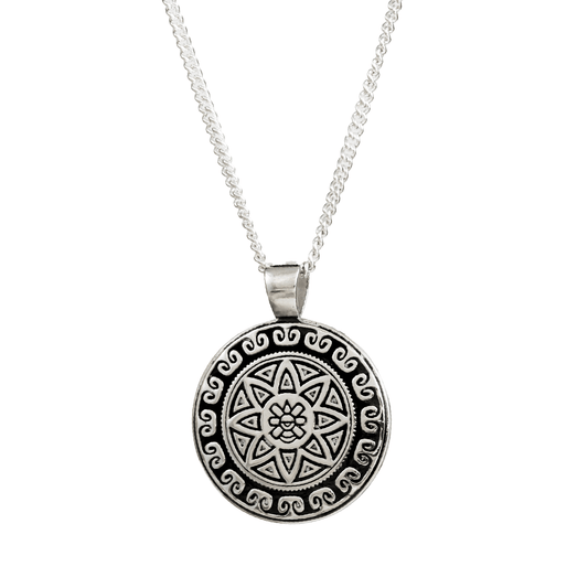 A silver mandala necklace with intricate Aztec Ollin design worn on a chain, featuring personalized engraving by Scarlett Jew