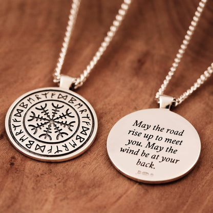 A silver Viking rune necklace with personalized engraving, displayed on a wooden background by Scarlett Jewellery.