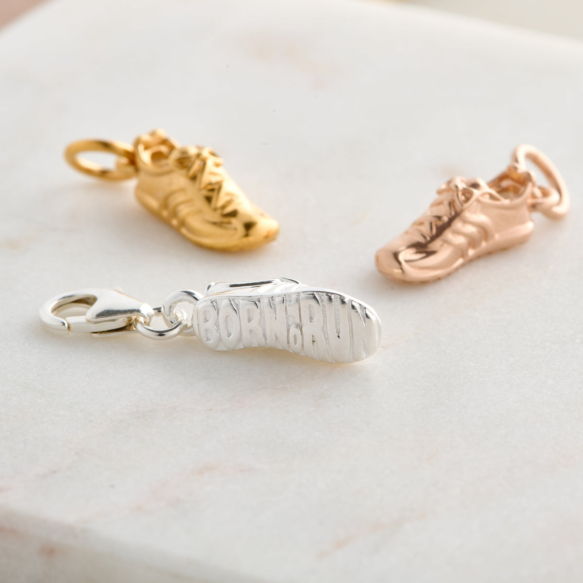 Silver charm with detailed etching on a running shoe by Scarlett Jewellery.