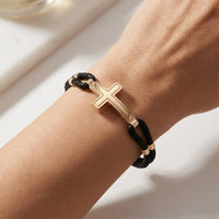 A sleek cross braided bracelet in 14ct gold detail by Majestic Jewellery.