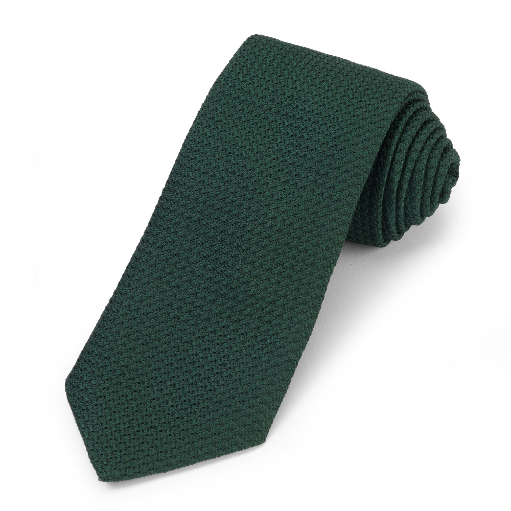 Forest green silk tie with subtle pattern, worn on a man's neck by Benson & Clegg.