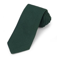 Forest green silk tie with subtle pattern, worn on a man's neck by Benson & Clegg.