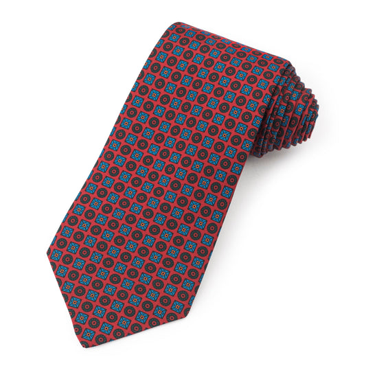 A red silk tie featuring square and circle patterns in ancient madder dye, displayed flat with detailed texture, by Benson & 
