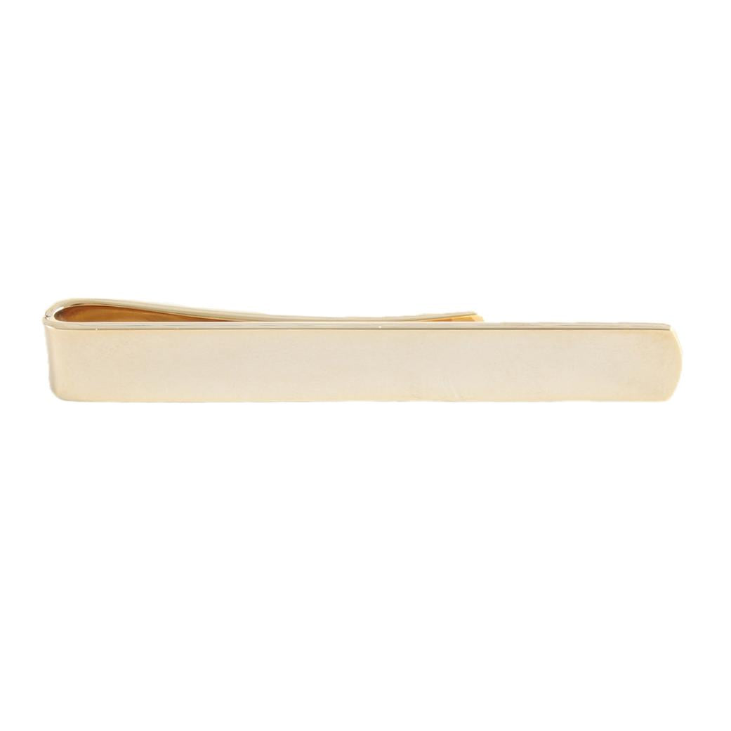 A golden slim tie slide with a sleek design, shown against a neutral background by Benson & Clegg.