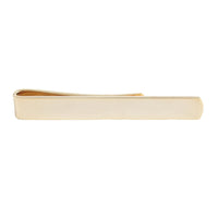 A golden slim tie slide with a sleek design, shown against a neutral background by Benson & Clegg.
