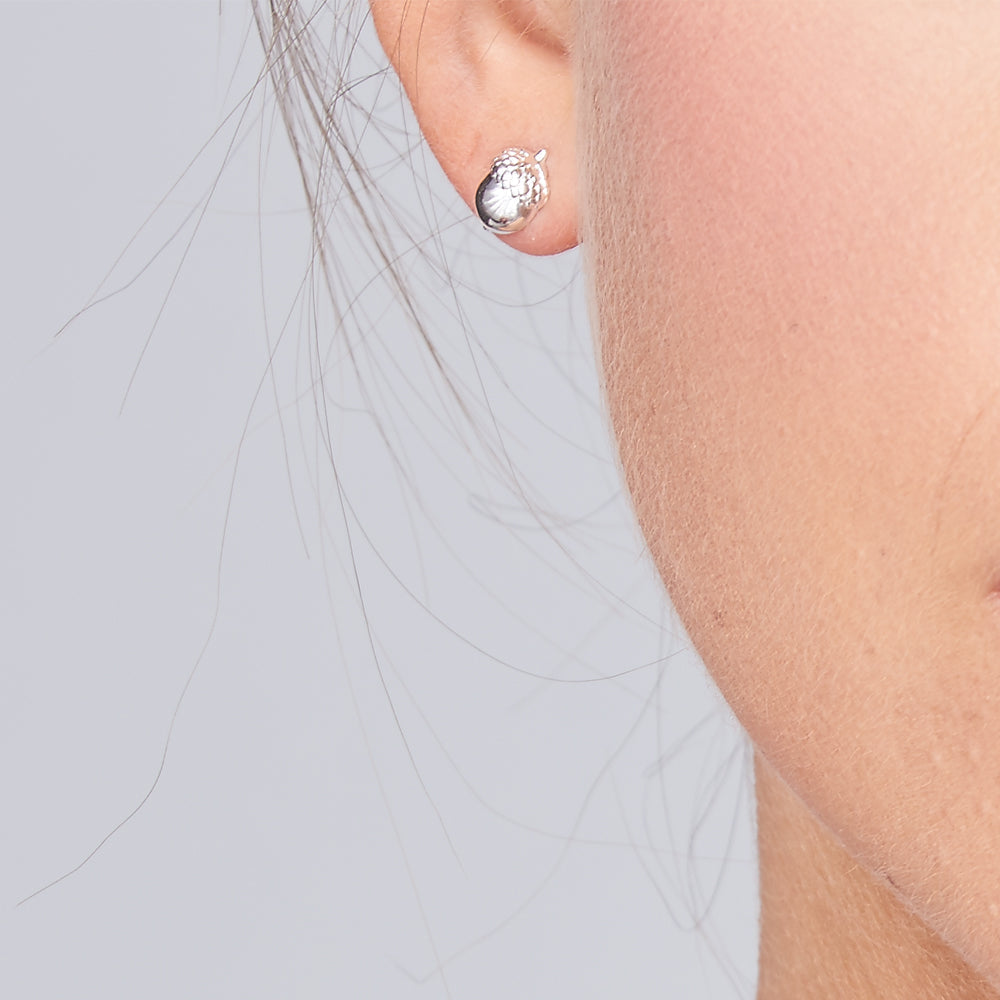 Silver acorn-shaped stud earrings with a polished finish, featuring a delicate design, by Scarlett Jewellery.