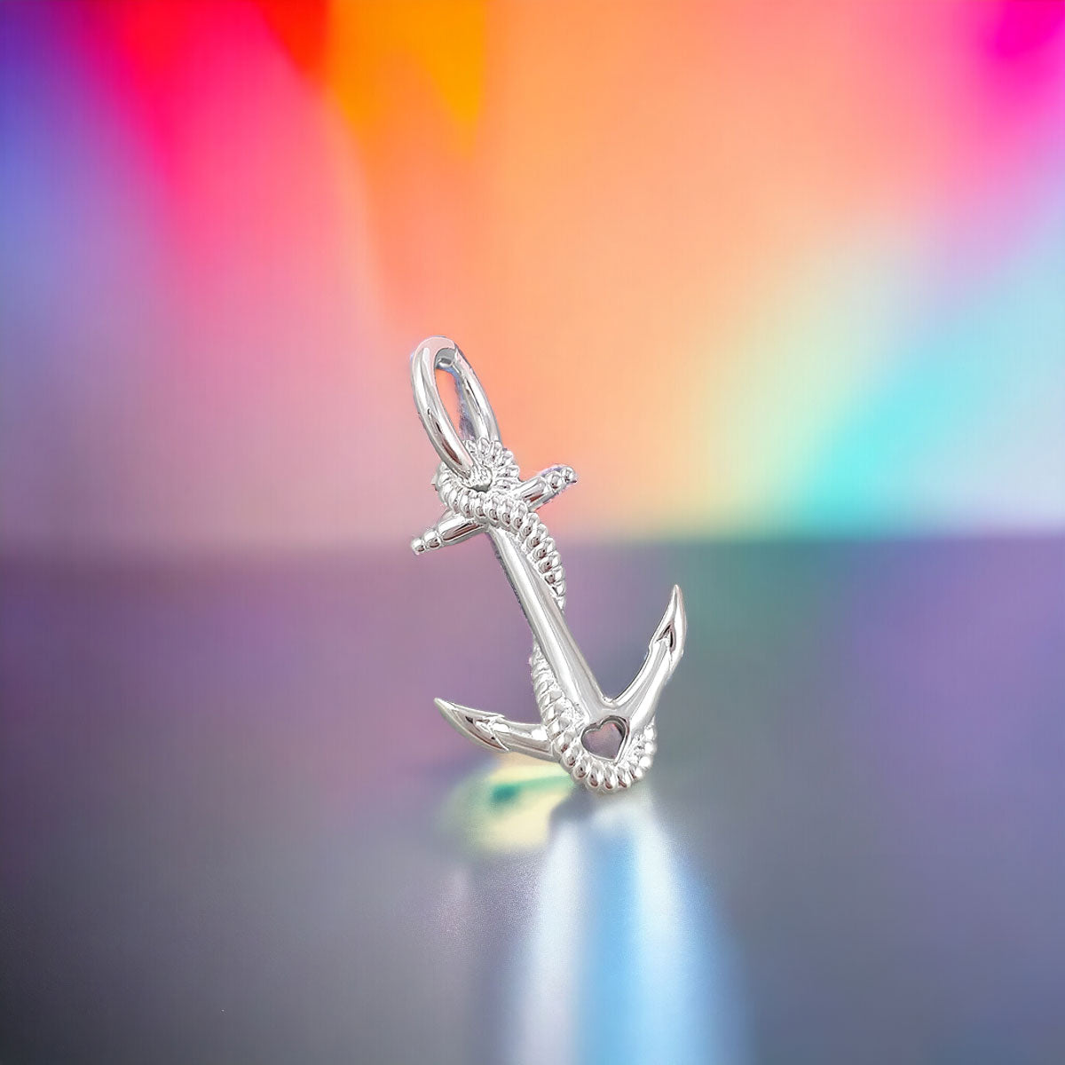 A silver anchor charm with intricate detailing, displayed on a soft white background, by Scarlett Jewellery.