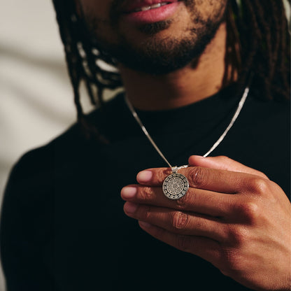 A silver mandala necklace with intricate Aztec design worn around the neck by Scarlett Jewellery