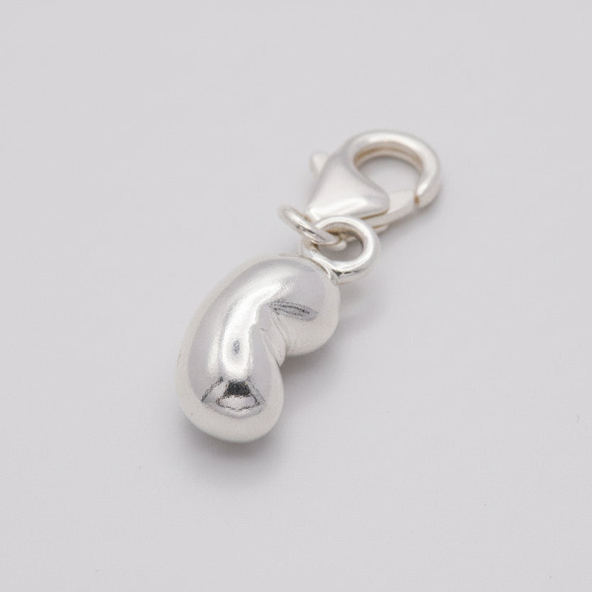 Silver baby bean charm with delicate detailing, styled on a necklace chain by Scarlett Jewellery.
